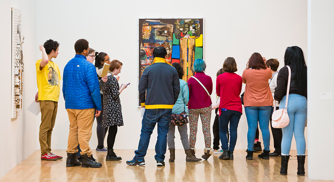 A group of people tour a gallery