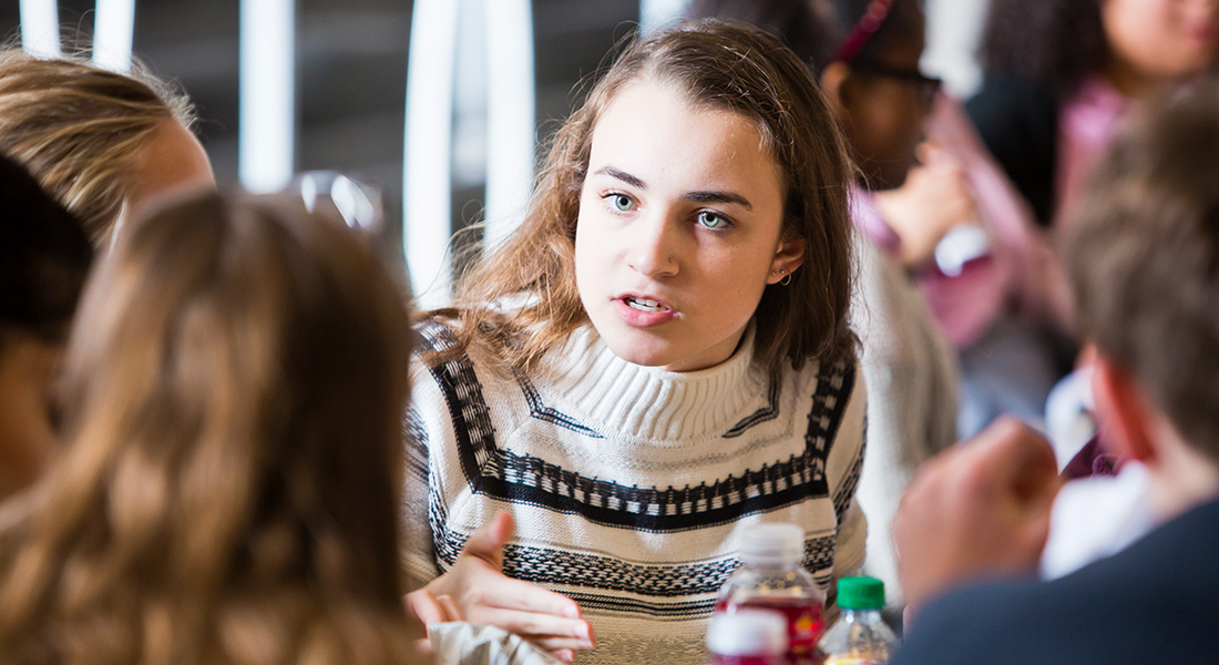 A student talks to her peers