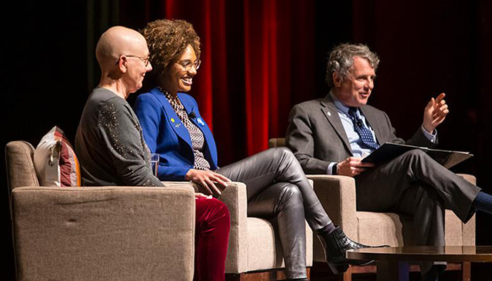 panelists, two women and a man, on a stage