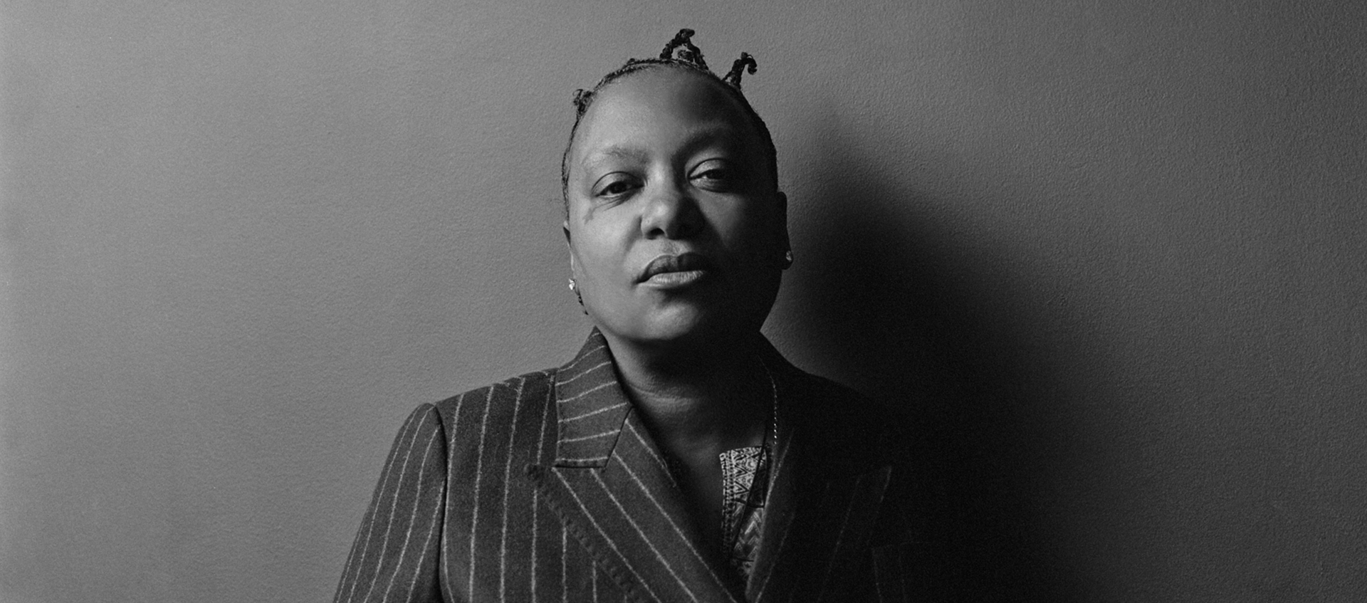 Black and white headshot of Meshell Ndegeocello wearing a pinstripe suit.