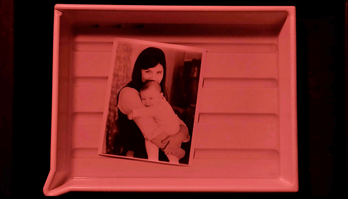 a photo of a woman holding a baby, the photo is in a tray.